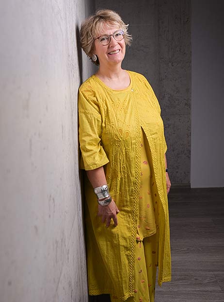 Porträt von Corinna Kulartz, angelehnt an einer Wand