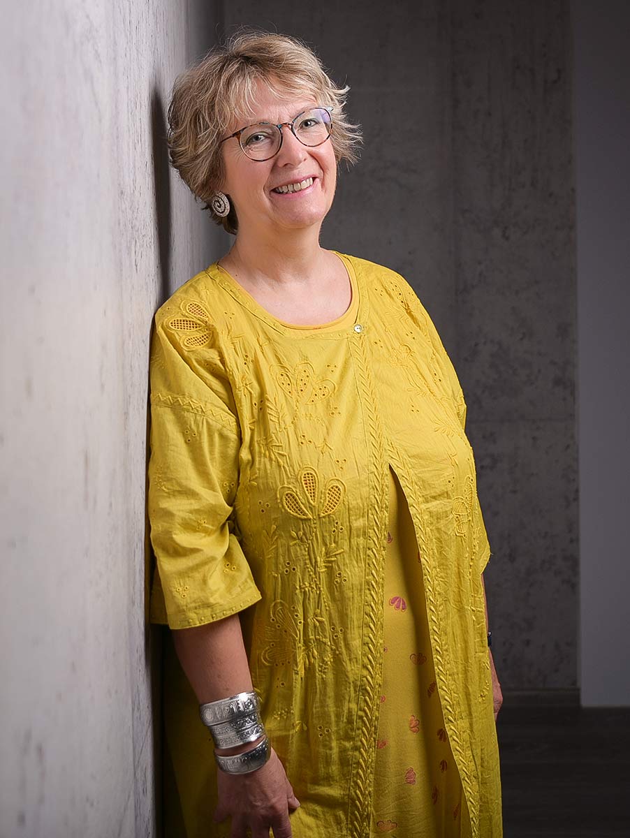 Porträt von Corinna Kulartz, angelehnt an einer Wand